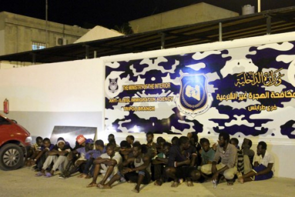 Men from African countries sit outside Tripoli's anti-illegal immigration agency on June 4, 2017. Seven migrants from sub-Saharan Africa were found dead in an abandoned refrigerator truck near the Libyan capital, according to a senior official in the fight against illegal immigration.