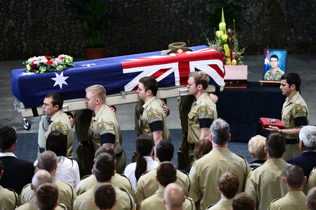 Australian soldiers carrying the coffin of one of their own.