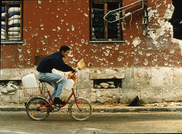 A boy going for water rushes across a dangerous intersection where some 20 people had, in recent weeks, been killed by snipers. Mostar was under siege and its residents were desperate for water. September 7, 1993.
