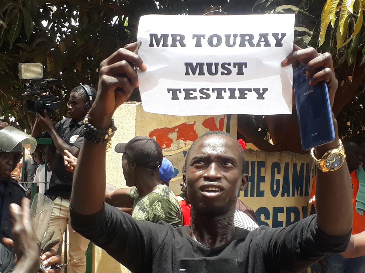 A protester holds up a sign on which is written 