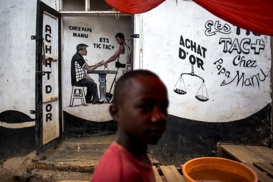 A Mambasa, en République démocratique du Congo (RDC), un enfant passe devant une boutique de négociant en or.