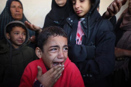 Des enfants palestiniens pleurent après que des membres de leur famille, dont des nourrissons, aient été tués lors d'une frappe aérienne israélienne sur leur abri à Deir el-Balah, dans le centre de la bande de Gaza, le 14 janvier 2025.