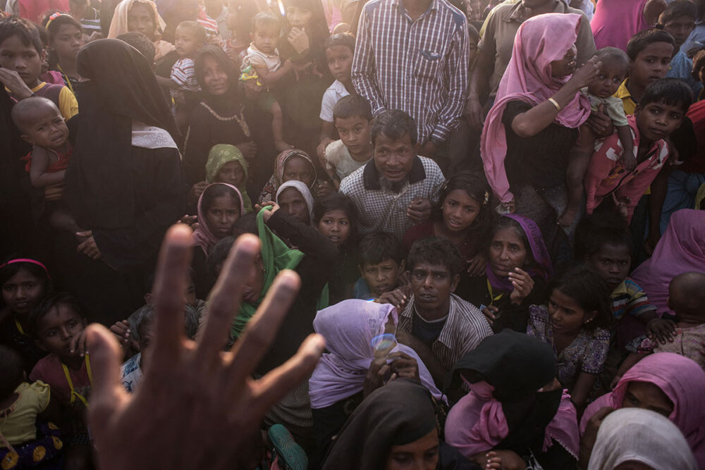 A group of Rohingya Muslim refugees are closely gathered, hoping to be called to recieve food aid of rice, water, and cooking oil in a relief centre at the Kutupalong refugee camp in Cox's Bazar.