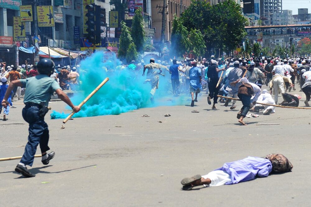 In Bangladesh, a local court is handling cases relating to crimes committed by the police during the crackdown on Islamist protests in 2013. Photo: protesters run to escape police armed with batons, whilst smoke bombs are being used.
