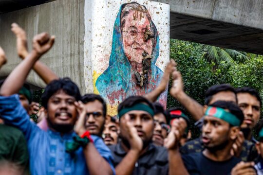 Sheikh Hasina's trial begins in Bangladesh. Photo: In August 2024, students protest against the head of state on a street in Dhaka, with a portrait of her painted on a wall in the background.