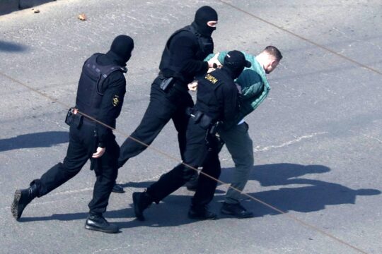 Belarus uses its political prisoners as bargaining chips in political, diplomatic and economic dealings, most often with the United States. Photo: Hooded police officers have handcuffed a civilian in the street and are forcibly taking him into custody.