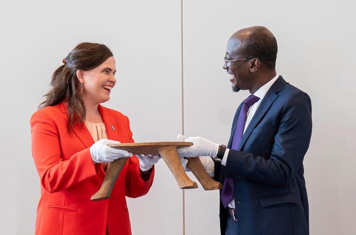 Restitution d'un objet culturel (tabouret royal) de la Finlande au Bénin. Photo : Mari-Leena Talvitie, ministre de la Science et de la Culture finlandaise, remet un tabouret royal anciennement pillé par la France au ministre béninois du Tourisme et de la Culture, Jean-Michel Abimbola.