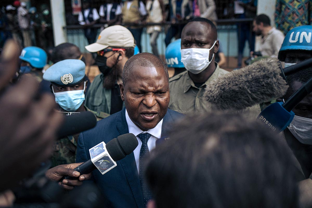 Faustin Archange Touadera, President of the Central African Republic, speaks to journalists. In the background, members of the UN.