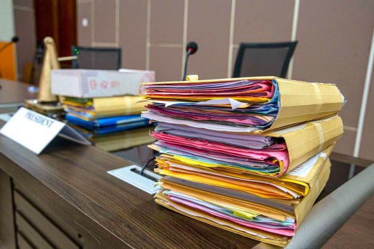 Sur le bureau du président de la Cour pénale spéciale (CPS), en Centrafrique, 2 piles de dossiers multicolores.