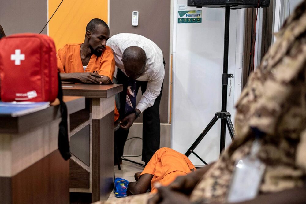1er jugement de la Cour pénale spéciale (CPS) en Centrafrique - Issa Sallet Adoum observe Mahamat Tahir, allongé par terre, affaibli par une grève de la faim. Ce sont 2 des 3 accusés au procès.