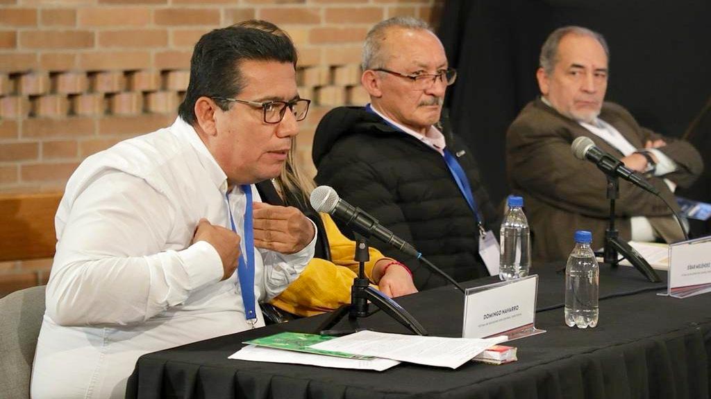 A man (Domingo Navarro) speaks into a microphone during a hearing of the Jurisdicción Especial para la Paz (JEP) in Colombia.