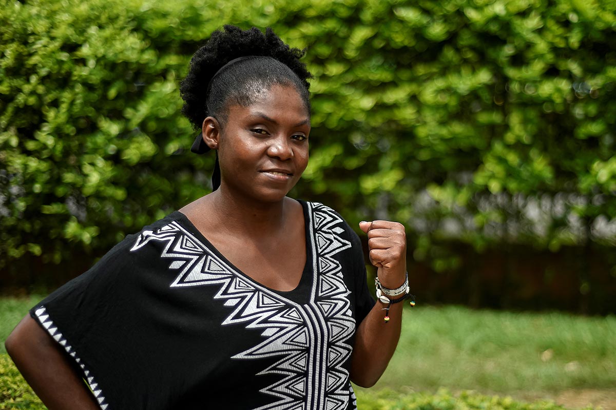 Afro-Colombian Francia Marquez raises her fist while staring at the camera lens