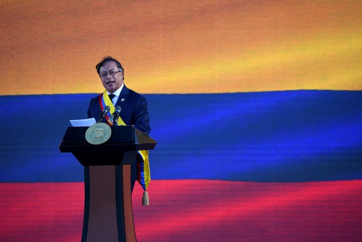 El nuevo presidente de Colombia, Gustavo Petro, pronuncia un discurso en un podio. En el fondo: la bandera de Colombia.