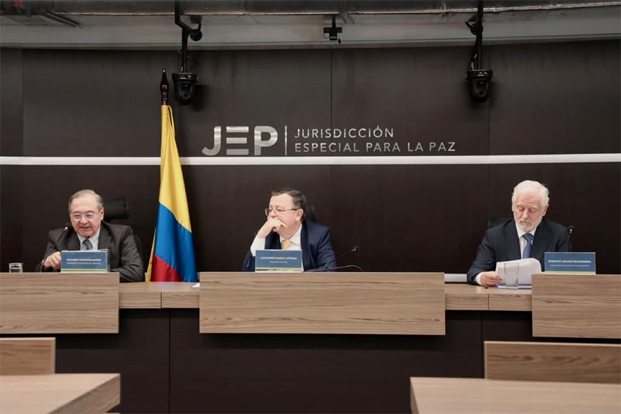 JEP Justice Eduardo Cifuentes (left) reads the appeals ruling that provided more clarity on the sanctions for seven former FARC top commanders.