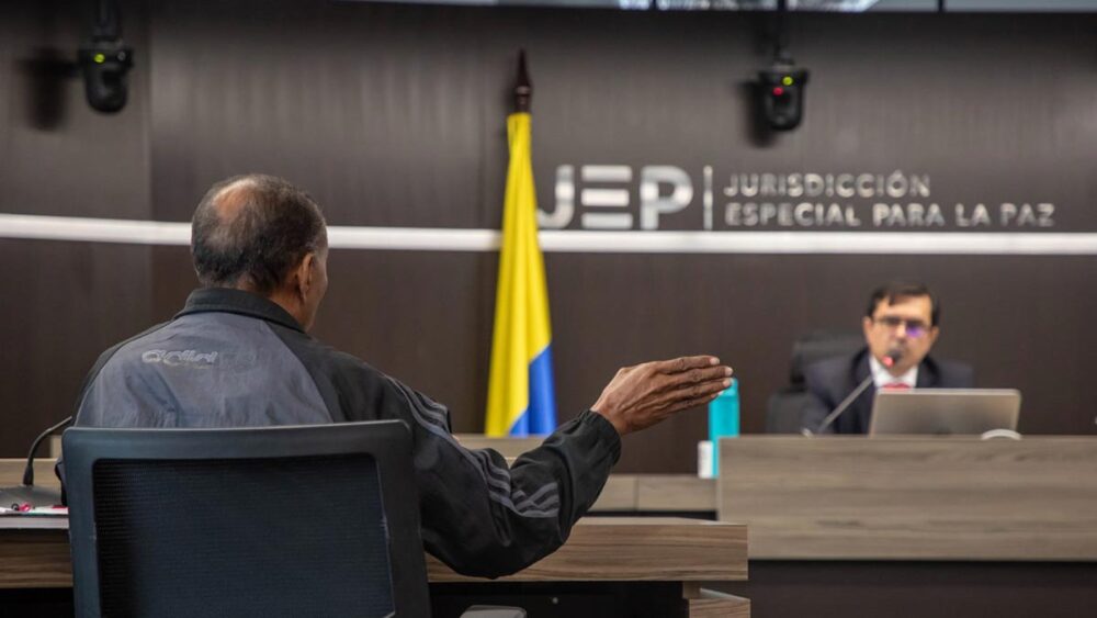 A senior jurist from the Special Jurisdiction for Peace (JEP) listens to a victim in Colombia.