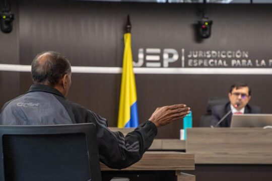 A senior jurist from the Special Jurisdiction for Peace (JEP) listens to a victim in Colombia.
