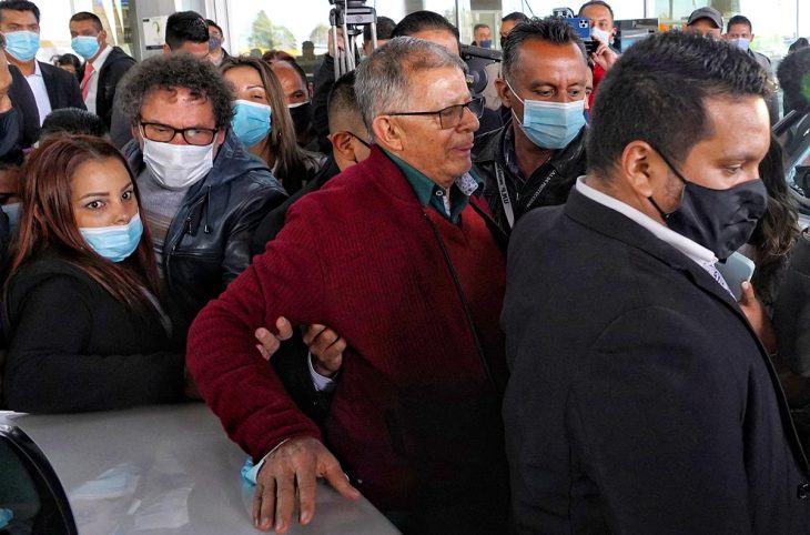 Rodrigo Granda entouré d'une foule de personnes dont certaines le tiennent le bras, à l'aéroport de Bogota en Colombie