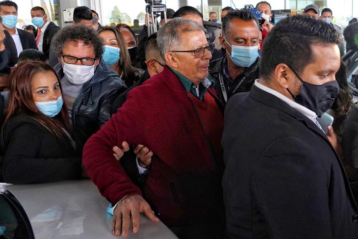 Rodrigo Granda entouré d'une foule de personnes dont certaines le tiennent le bras, à l'aéroport de Bogota en Colombie