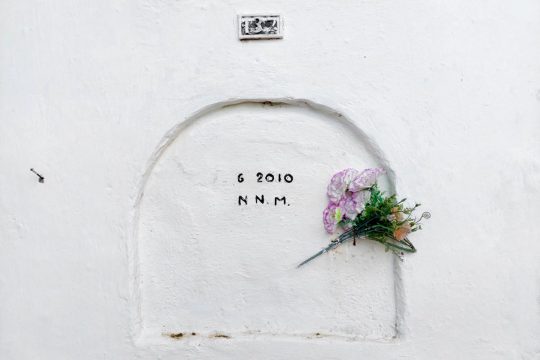 Grave of a missing and unidentified person in Colombia (inscription: "6 2010 N. N. M.". A bouquet of flowers is placed on it.