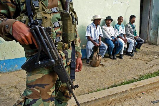 A Colombian soldier stands near civilians in the street