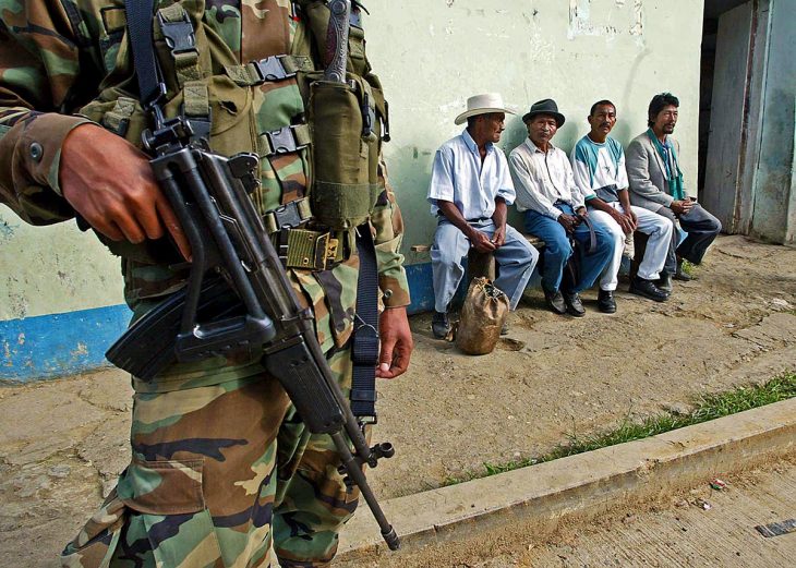 A Colombian soldier stands near civilians in the street