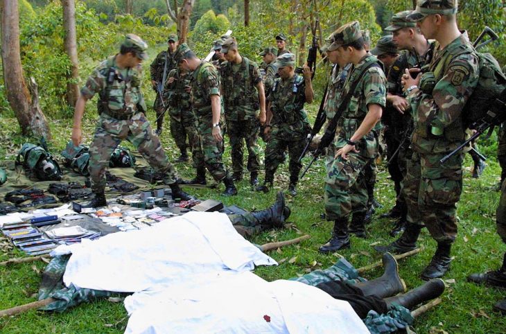 Colombian army soldiers look at the bodies of dead FARC rebels