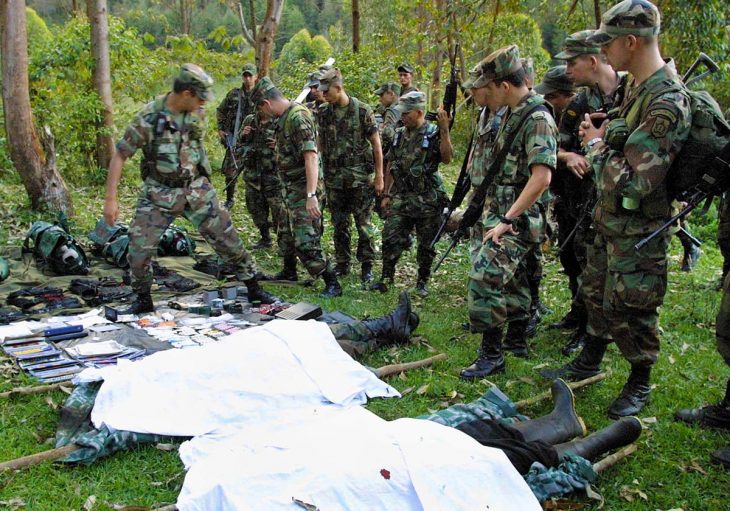 Colombian army soldiers look at the bodies of dead FARC rebels