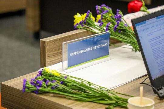 Colombia's Special Jurisdiction for Peace (JEP) seeks the truth for victims of FARC kidnappings. Photo: before JEP, flowers and a computer are placed on the desk of the victims' representatives.