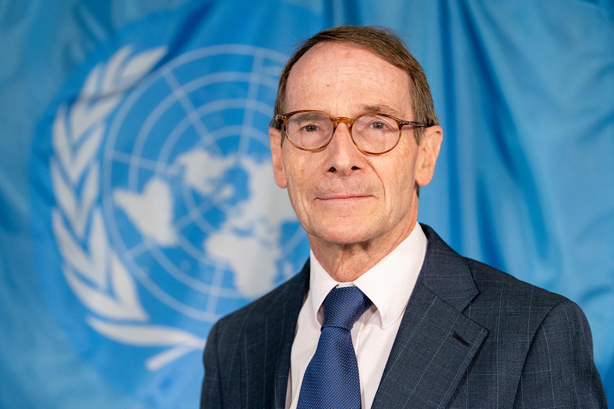 Portrait of Erik Mose, with the United Nations flag behind him