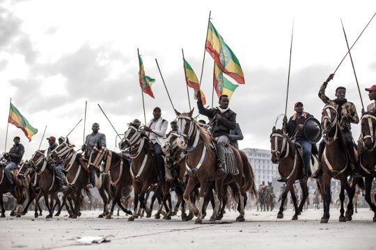 Riders hold up the Ethiopian flag