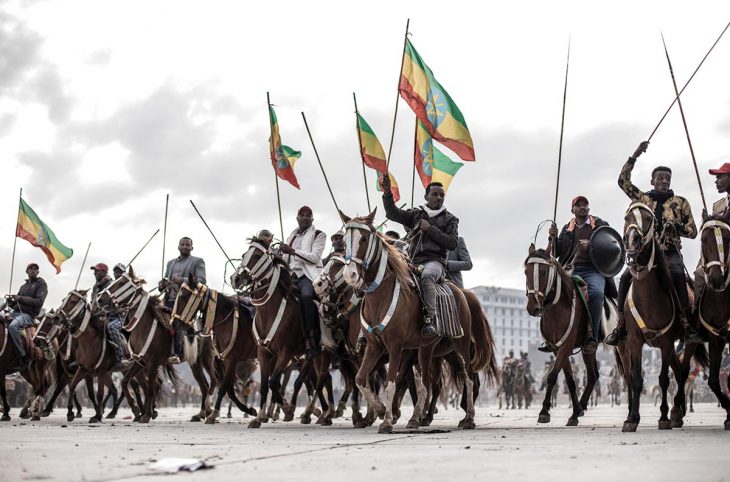 Riders hold up the Ethiopian flag