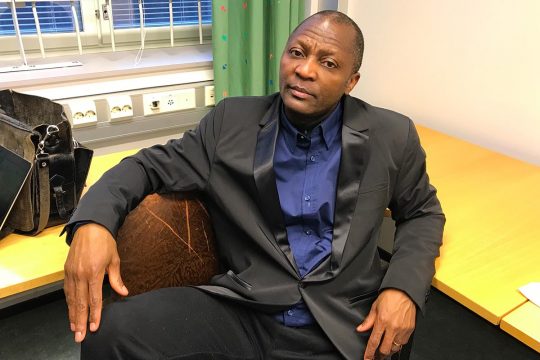 Gibril Massaquoi, pensive, is installed in an armchair