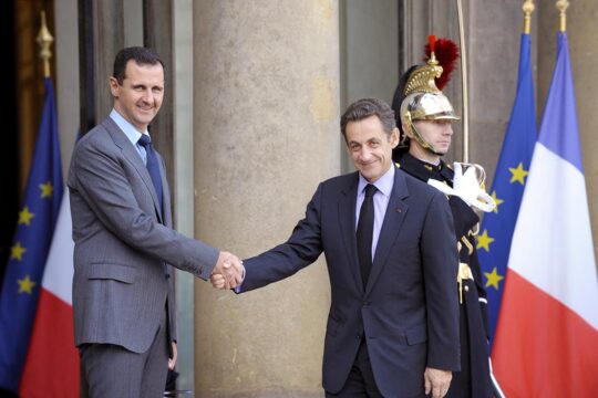 Syria / France - When French justice rethinks the impunity of heads of state. Photo: On the steps of the Elysée Palace in Paris, Nicolas Sarkozy and Bashar al-Assad smile as they shake hands.