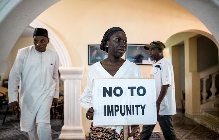 En Gambie, une femme tient une pancarte disant "non à l'impunité" (en anglais).