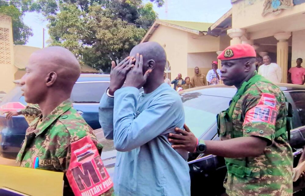 Sanna Manjang (a former Gambian jungler) was handed over by Senegal to Gambia. Photo: Manjang is handcuffed and escorted by men in military uniforms.