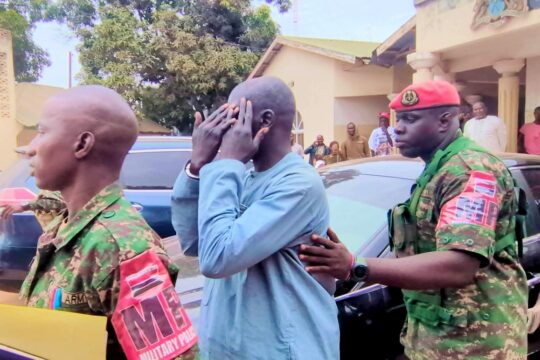 Sanna Manjang (a former Gambian jungler) was handed over by Senegal to Gambia. Photo: Manjang is handcuffed and escorted by men in military uniforms.