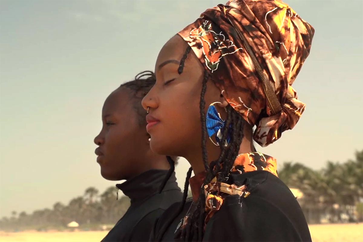 Toufah JalloToufah Jallow et une autre femme regardent l'horizon depuis une plage gambienne