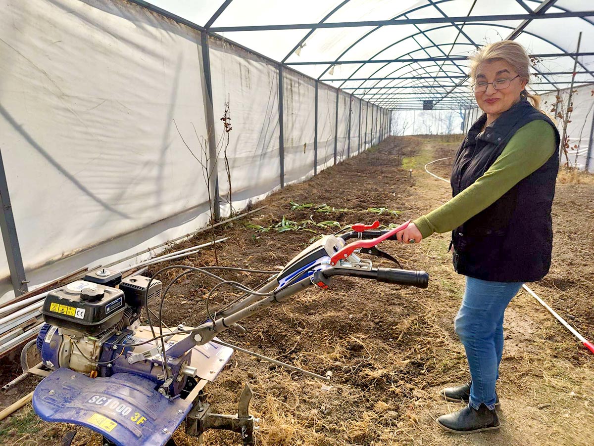 Maguli Okropiridze, victime de la guerre en Géorgie et bénéficiaire du programme d'assistance du Fonds de la Cour pénale internationale (CPI) au profit des victimes. Photo : Okropiridze montre le motoculteur qu'elle a financé grâce aux fonds de la CPI.