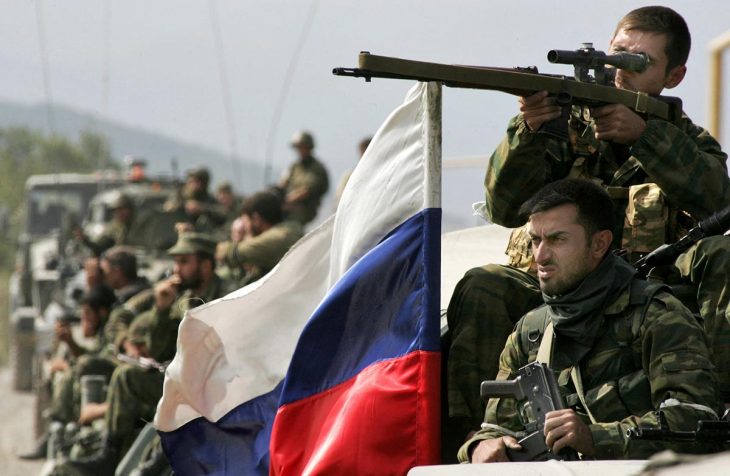 Russian soldiers (including a sniper) in Georgia. A Russian flag flutters in the wind.