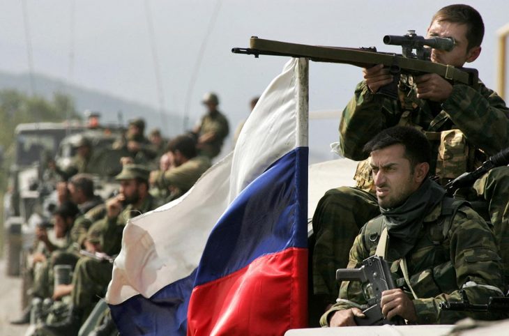 Russian soldiers (including a sniper) in Georgia. A Russian flag flutters in the wind.
