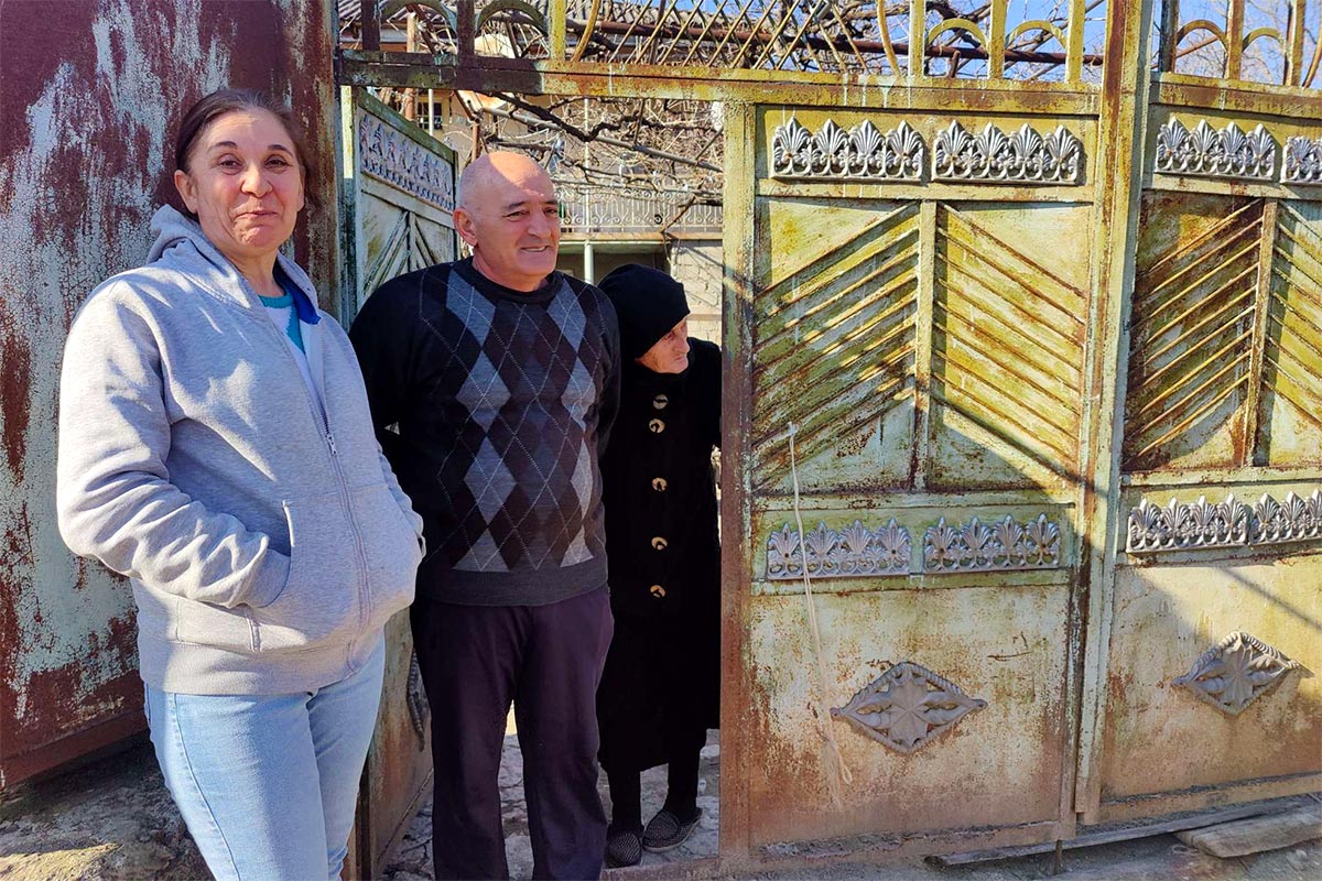 Victimes de la guerre en Géorgie et bénéficiaires du programme d'assistance du Fonds de la Cour pénale internationale (CPI) au profit des victimes. Photo : Mevloud Kharazishvili, Elsa Gagaladze et Olia Tsarazishvili devant la porte de leur maison dans le hameau géorgien de Tchvrinisi