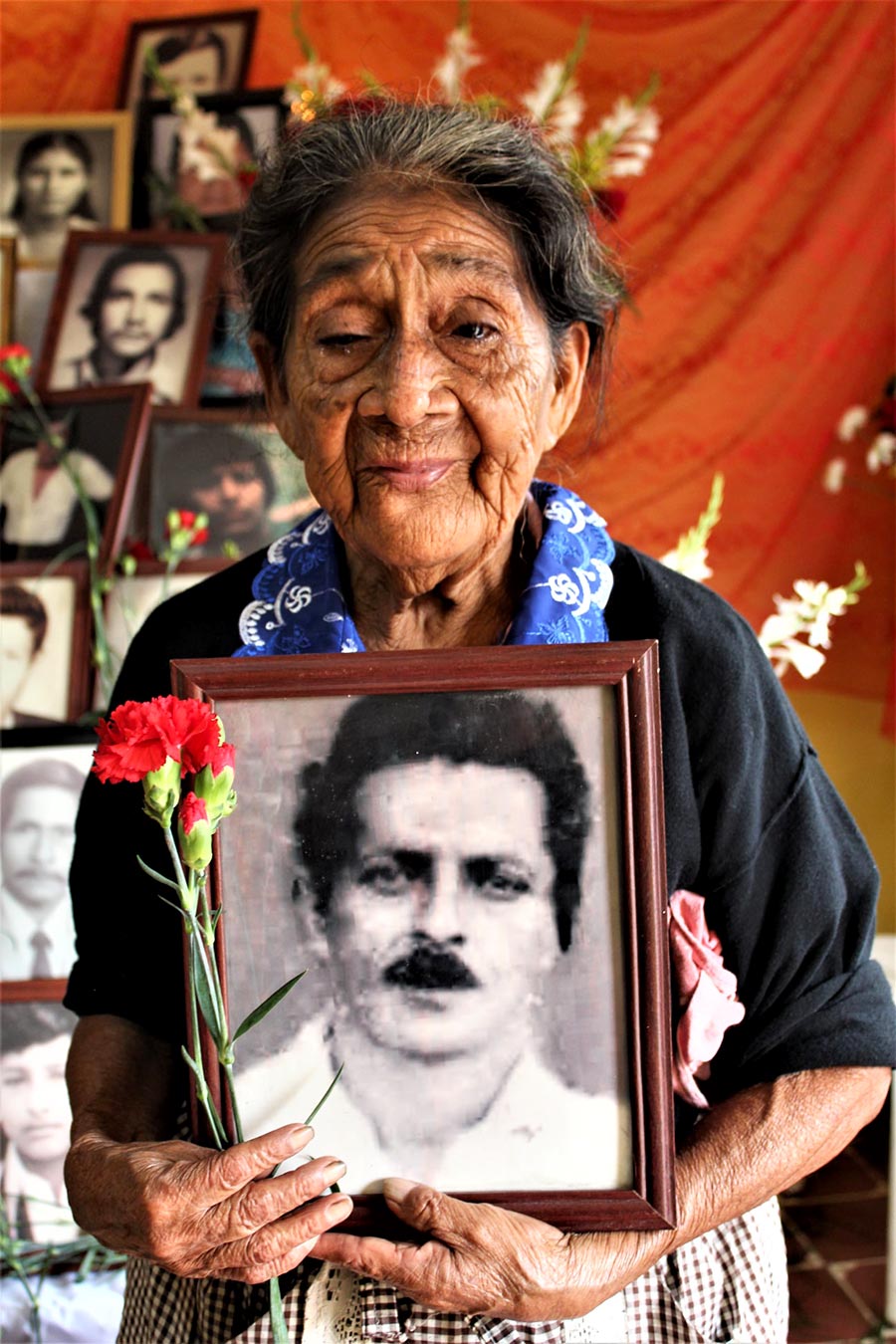 Doña Dominga Alvarado Vasquez, holds the portrait of her husband who disappeared in Guatemala in 1985.