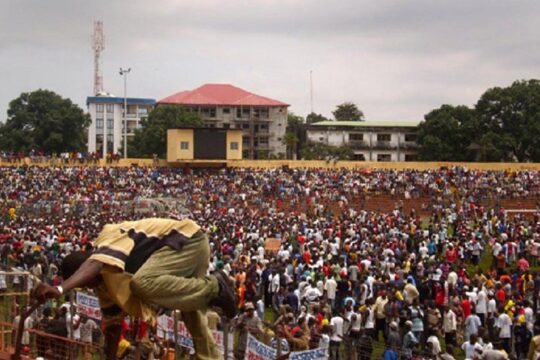 At the 28 September trial in Guinea, will the Conakry stadium massacre be requalified as a crime against humanity? Photo: A participant in the political meeting climbs over a barrier at the stadium (which was crowded) on 28 September 2009.