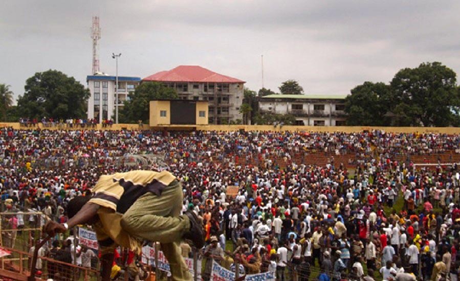 At the 28 September trial in Guinea, will the Conakry stadium massacre be requalified as a crime against humanity? Photo: A participant in the political meeting climbs over a barrier at the stadium (which was crowded) on 28 September 2009.