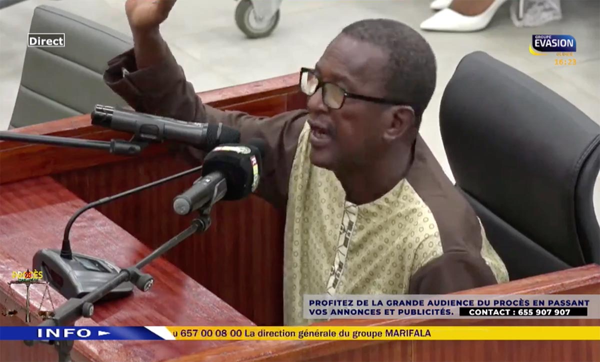 Capture d'écran d'une vidéo diffusée sur la chaîne de télévision guinéenne  Evasion TV durant le procès du massacre au stade de Conakry. Un bandeau publicitaire apparaît en bas de l'image : 