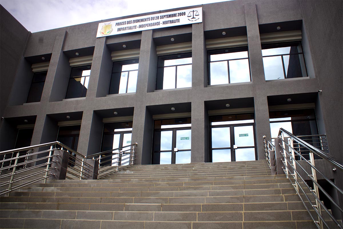 L'entrée du tribunal ad hoc de Conakry (Guinée) en haut d'un escalier imposant. Un écriteau indique : "Procès des événements du 28 septembre 2009. Impartialité - indépendance - neutralité". 