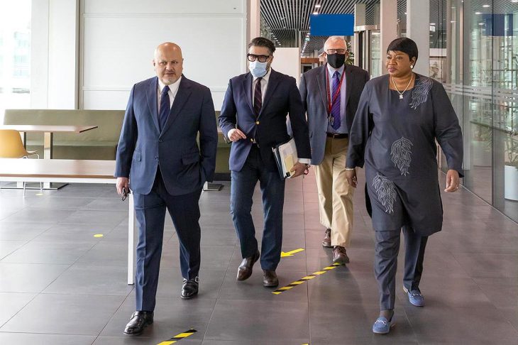 Fatou Bensouda and Karim Khan walk side by side in the corridors of the International Criminal Court