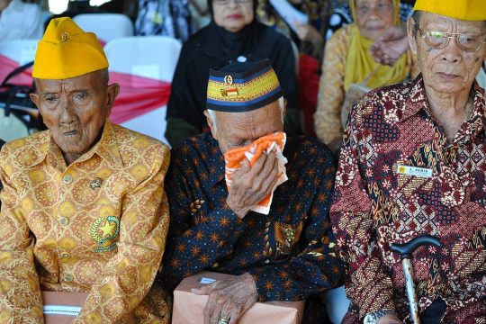 3 Indonesian veterans (one crying) attend a commemoration ceremony for the victims of the war of independence against the Netherlands