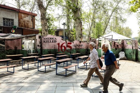In Iran, the population is both a victim of US-Israeli aggression and a victim of repression by the Iranian regime. What hope is there for justice? Photo: Two Iranians walk past a mural commemorating schoolchildren from Minab who are believed to have been killed by a missile. School desks and benches are laid out on the pavement.