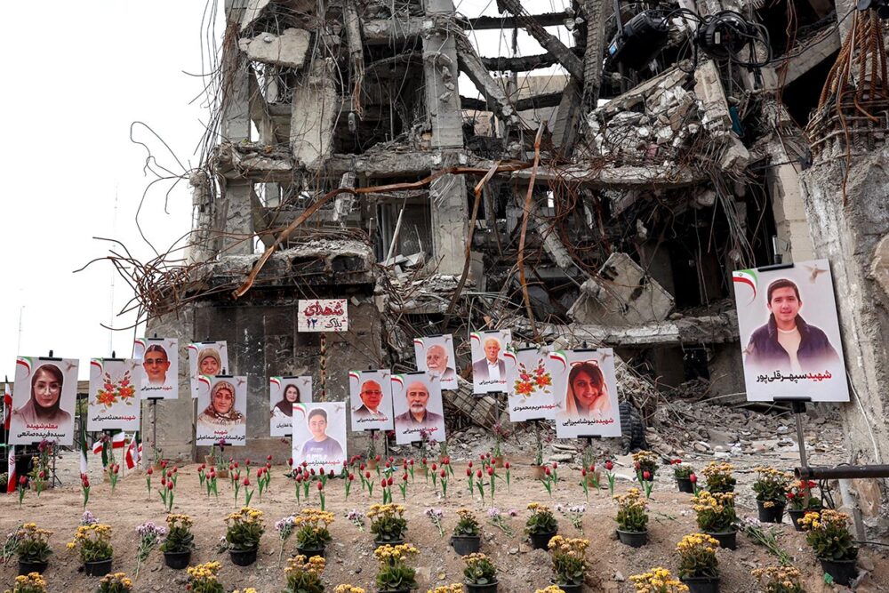 In Iran, portraits of victims believed to have been killed in a US-Israeli airstrike on a residential building in Tehran are on display in the street in front of the destroyed building. Flowers have also been placed on the ground.